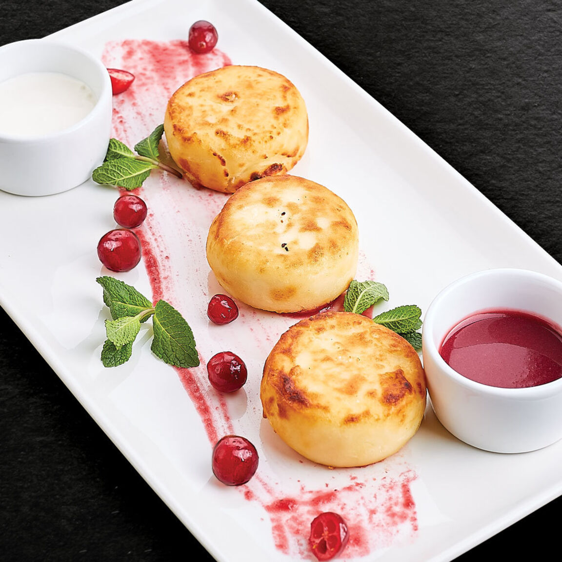 Сырники со сметаной и клюквенным соусом